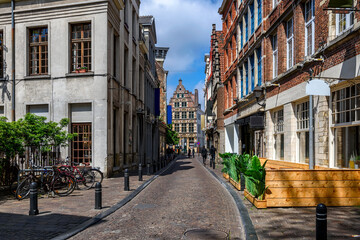 Old narrow street with tables of cafe in Ghent (Gent), Belgium. Architecture and landmark of Ghent. Cozy cityscape of Ghent.