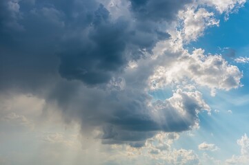 Obraz premium Overcast sky signaling rain with a panoramic view of dramatic sunlight and mixed clouds on a bright summer day