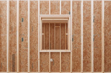 Two-story home being built featuring timber framing on particle board and a rectangular window opening, representing simplicity, innovation, intention, and architecture.