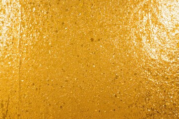 Obraz premium Luxurious golden surface featuring sparkling glitter and bright light reflections, ideal for festive wallpapers and decorative backgrounds