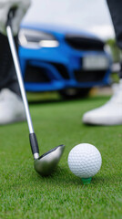 Golf club and ball close-up on green with blue car in background