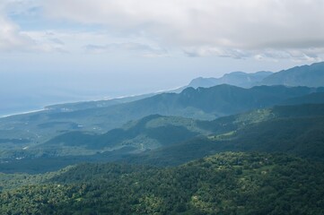 Fototapeta premium Scenic tropical mountain and forest with ocean and sky panorama during summer getaway