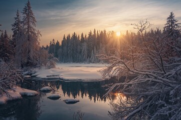 Fototapeta premium Snow-covered lake scene in winter with trees and serene water