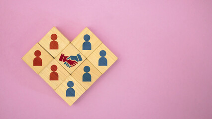 Handshake Partnership with People Icons on Wooden Blocks over Pink Copy Space