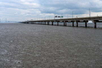 mudflat beach and long bridge on a cloudy day