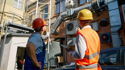 Engineers examining outdoor ventilation and air systems. Concept of engineering services, HVAC...