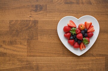 Conceptual representation of managing diabetes and cholesterol through a nutritious diet aimed at reducing cardiovascular disease risk, featuring fresh fruits arranged in a heart-shaped dish and