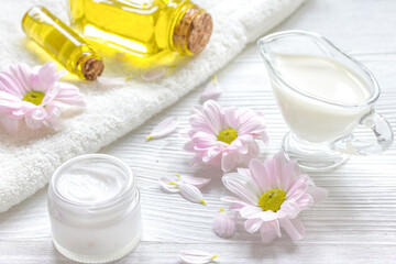 flowers in bowl and oil on wooden background