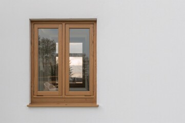Obraz premium Exterior view of a home featuring wooden framed windows and white plastered walls