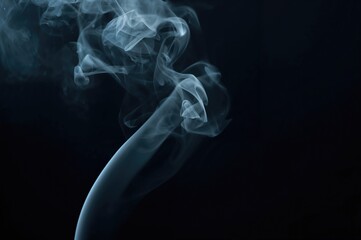 Obraz premium Light-colored vapor gently spreading over a black backdrop