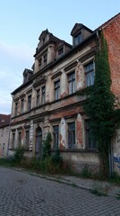Naklejka premium Dilapidated building in urban setting: An aged and weathered building, a testament to time, stands with faded glory in an urban environment, whispering tales of its past. 