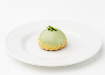 Gourmet Pistachio Cream Puff (Choux à la Crème) on a White Plate