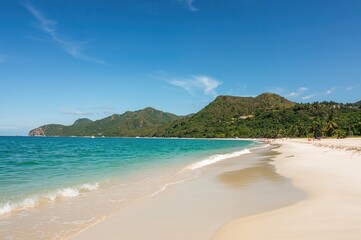 Scenic outlook of a coastal beach with rocky cliffs and clear waters