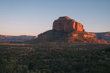Fototapeta premium Scenic perspective of a prominent rock formation from a nearby highway in the desert region