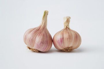 Fototapeta premium Two garlic bulbs against a plain white backdrop. Nutritious produce. Organic nutrients. Detailed close-up image.