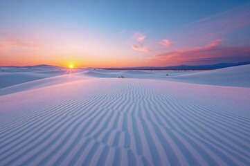 Desert landscape with white dunes under a colorful sunset sky