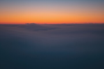 Stunning sunset casting vibrant hues over a foggy bay, where the mist creates a boiling sea effect.