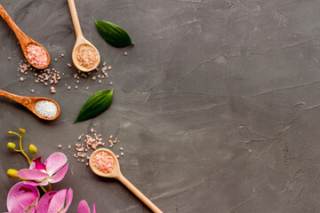 Obraz na płótnie Canvas Beauty spa therapy cosmetics and wellness flat lay - sea salt in many spoons with flowers, top view