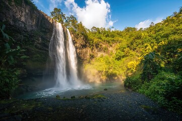 Obraz premium Cascading waterfall amidst lush island greenery