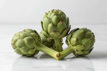 Obraz premium Raw Green Artichokes Arranged on a White Background