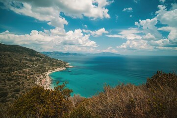 Scenic coastline with a prominent rock formation in the background during summer