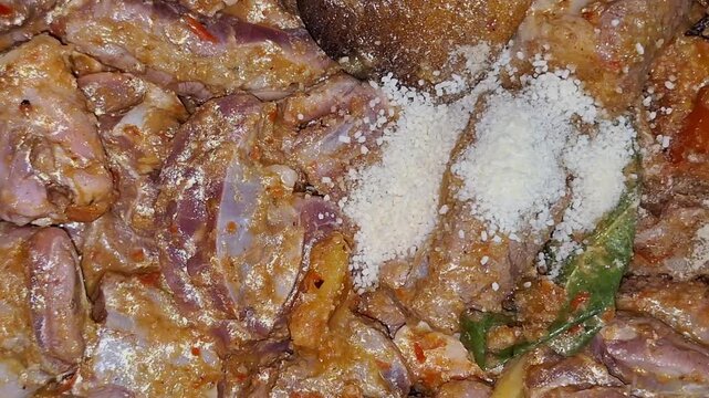 Adding seasoning to beef chunks for making Semur Daging.