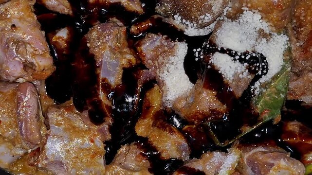 Close-up of beef being seasoned and coated with sweet soy sauce before simmering.