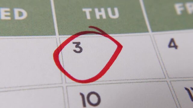 The 3rd on the calendar is circled in red marker in a close-up macro shot on a white page.