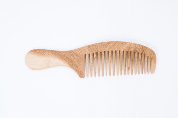 Wooden hair comb on a plain white backdrop with space for text