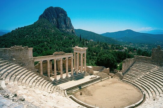 Historic stadium near the ancient sanctuary ruins, featuring classical marble architecture and stone structures amidst mountainous terrain - Powered by Adobe