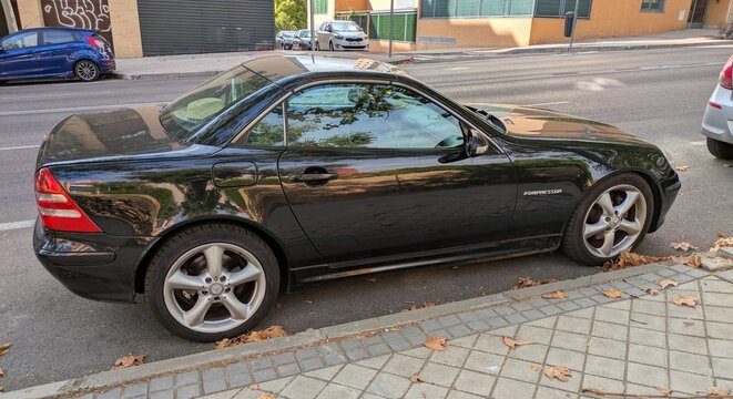 Vista lateral de un autom&oacute;vil descapotable Mercedes-Benz SLK aparcado en una calle de Madrid, Espa&ntilde;a, 6 de octubre de 2025