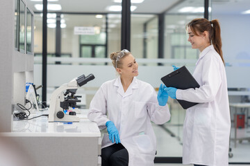 Lab technicians collaborate in a modern laboratory while discussing findings and using advanced equipment