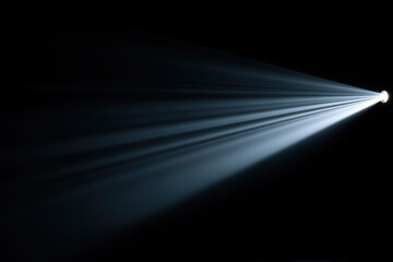 Bright white light beam shining through darkness with visible rays creating dramatic and focused effect