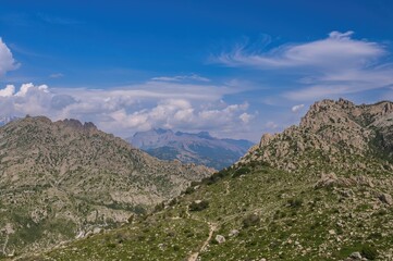 Naklejka premium Rocky peaks rising under a clear blue sky near a coastal resort area.