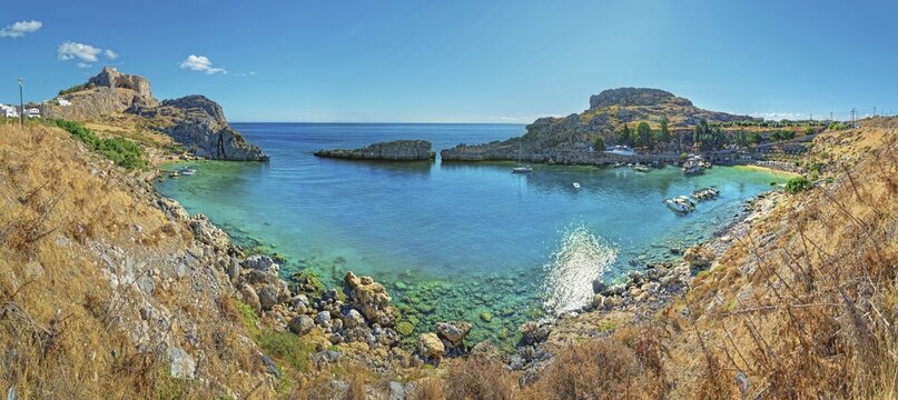 Clear panoramic view of Paulus Bay of Lindos with turquoise water and boats, Acropolis, Lindos, Rhodes, Island, Greece