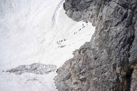Mountaineers queuing at the transition from the H&ouml;llentalferner to the Zugspitz via ferrata, on a snowfield, overtourism, mountain basin with glacier remnant of the H&ouml;llentalferner, H&ouml;llental, rocky mountain peaks, H&ouml;llental, Bavaria, Germany