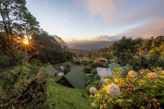 Cabins of a lodge in the cloud forest, in the evening light, Paraiso Quetzal Lodge, view over mountain landscape, sun star, San Jos&eacute; province, Costa Rica