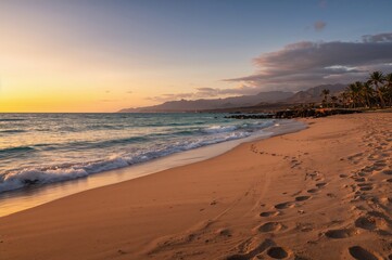 Beautiful coastal scene with ocean waves and footprints on sandy shore