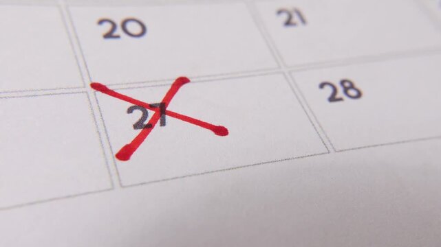 Marking the date number 27, focusing on the number highlighted with a red cross on the calendar. Represents deadlines, reminders, planning, and time management