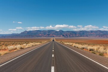 Endless highway with a solitary lane extending towards distant peaks. Vacation journey.