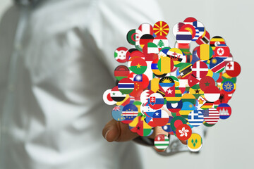 Close-up shot of a person's hand holding a collection of various national flags, symbolizing global...