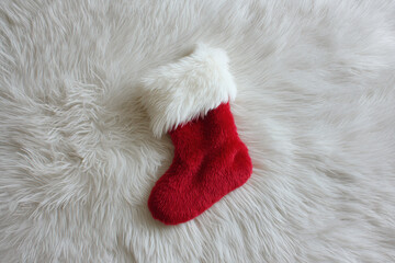 Red Christmas stocking, faux fur cuff, white fluffy rug, cozy holiday vibe
