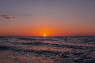 Obraz premium Sunset over the ocean with an orange sky