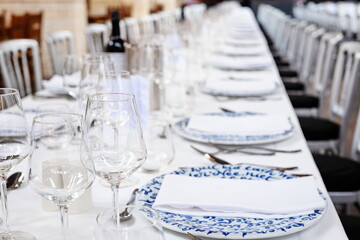 Empty wine glasses and plates on a set, formal dinner table. Close up shot, shallow depth of field, no people