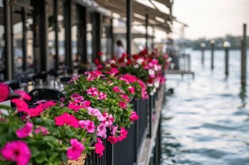 Fototapeta premium Outdoor dining area by the lake decorated with vibrant petunias in full bloom. Gentle blur, ample room for text.