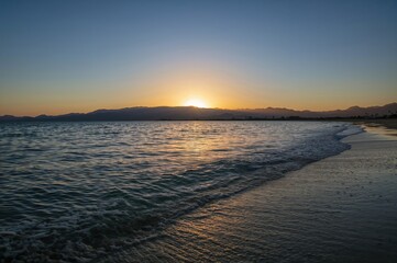 Fototapeta premium Morning sun emerging over the hills in a breathtaking scene, marking the start of a fresh day