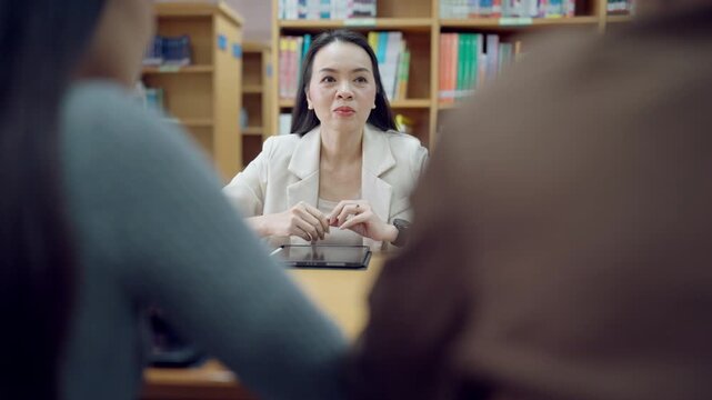 Female client signing business contract under legal supervision by professional advisor in law office environment.