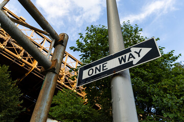One Way Street Sign with Bridge in Background
