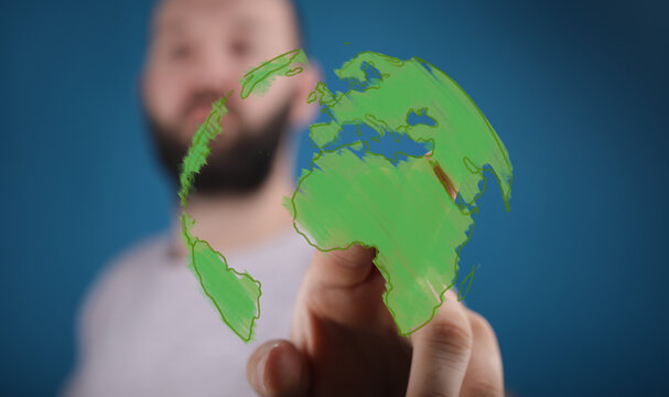 Eco-friendly concept. Man interacts with a green world map, symbolizing sustainability and global change. - Powered by Adobe