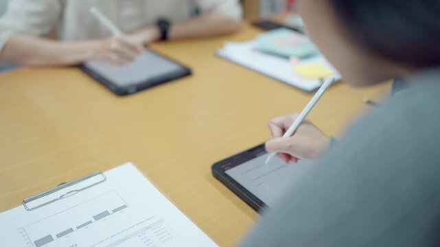 Close-up of female hands using stylus on tablet during business workshop or tech seminar, symbolizing modern learning tools. - Powered by Adobe
